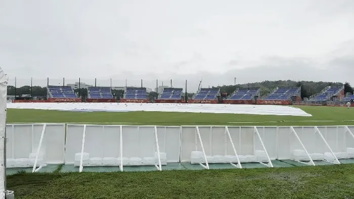 Covers on the pitch and empty stands at the rain-hit cricket ground in Nisshin, Japan