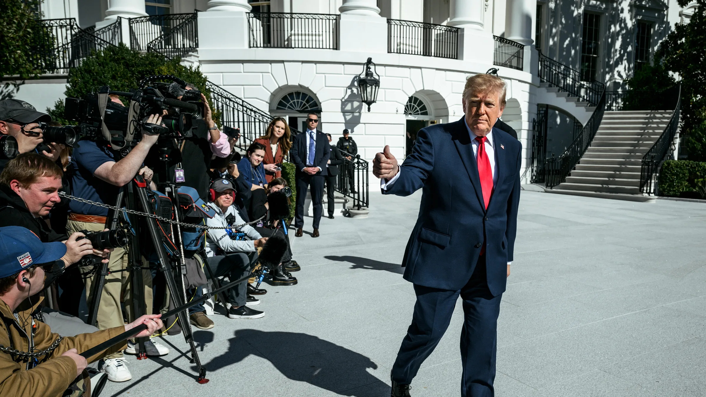President Donald Trump walking past reporters outside the White House