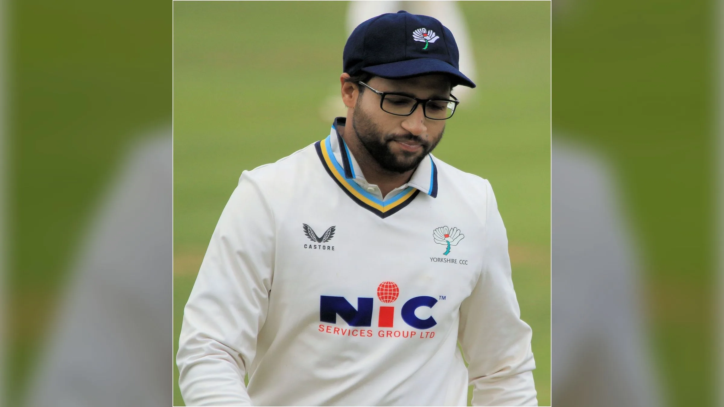 Imam-ul-Haq in cricket whites and a navy cap on a cricket ground