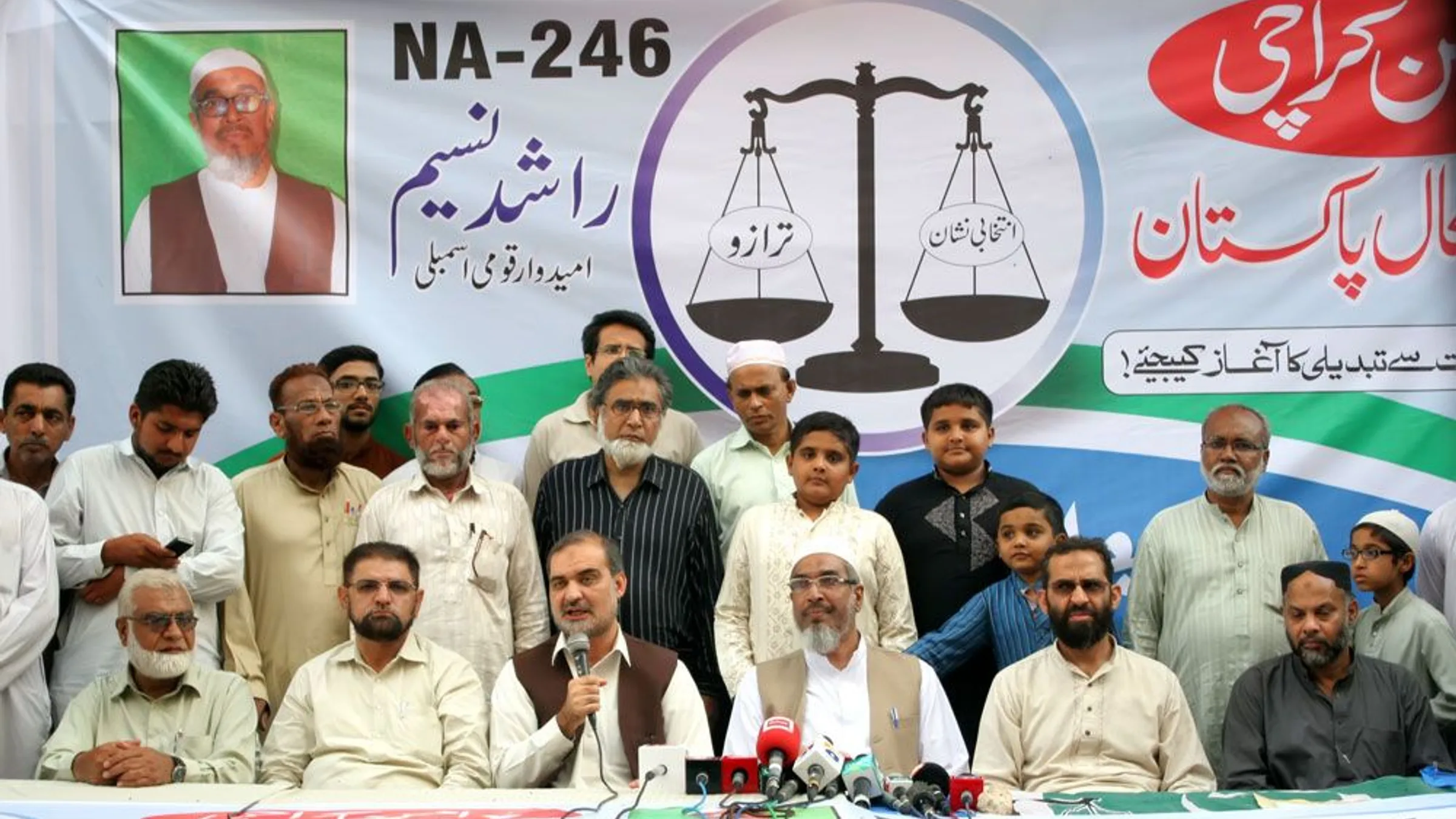 Jamaat-e-Islami leaders and workers seated at a press event in Karachi under a party banner