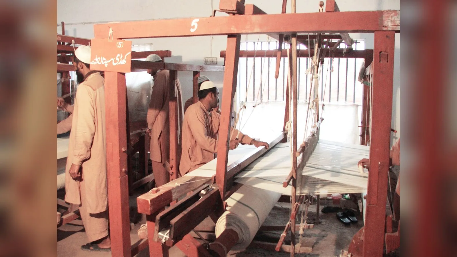 Prisoners weaving cloth on a traditional loom at a jail workshop in Pakistan