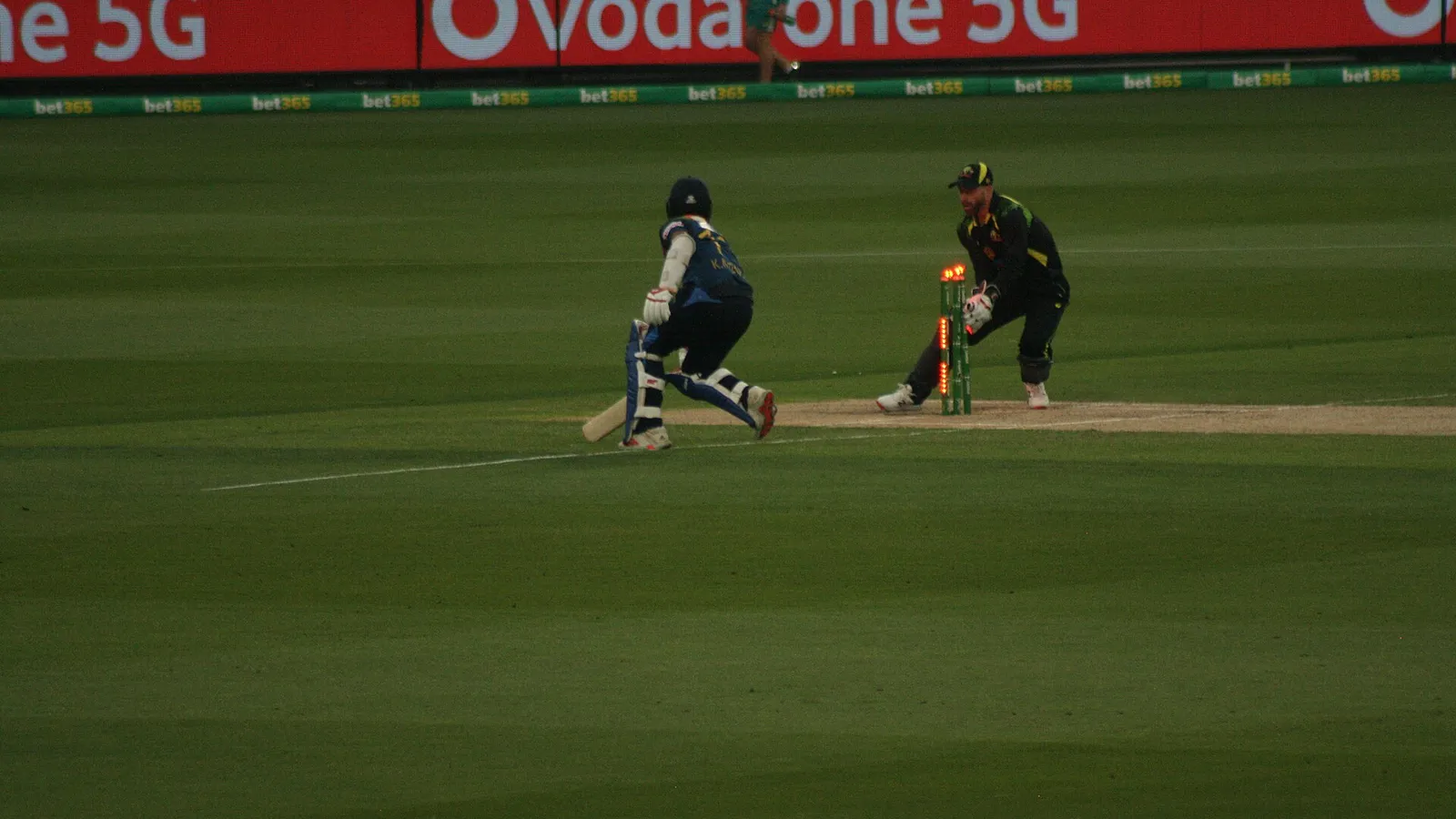 Kusal Mendis bats as a fielder attempts a run-out during a T20 international