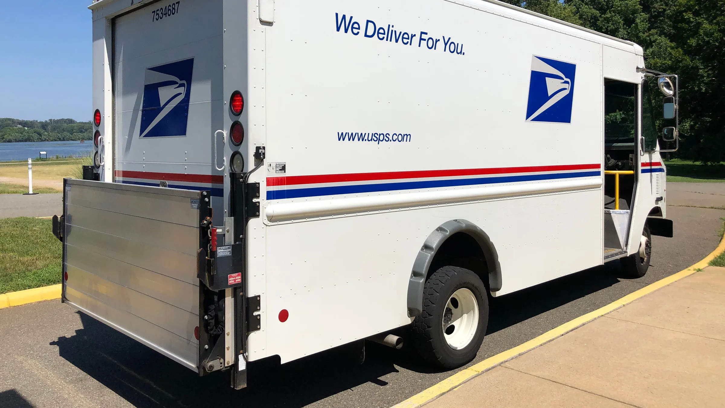 A white United States Postal Service delivery truck parked on a residential street