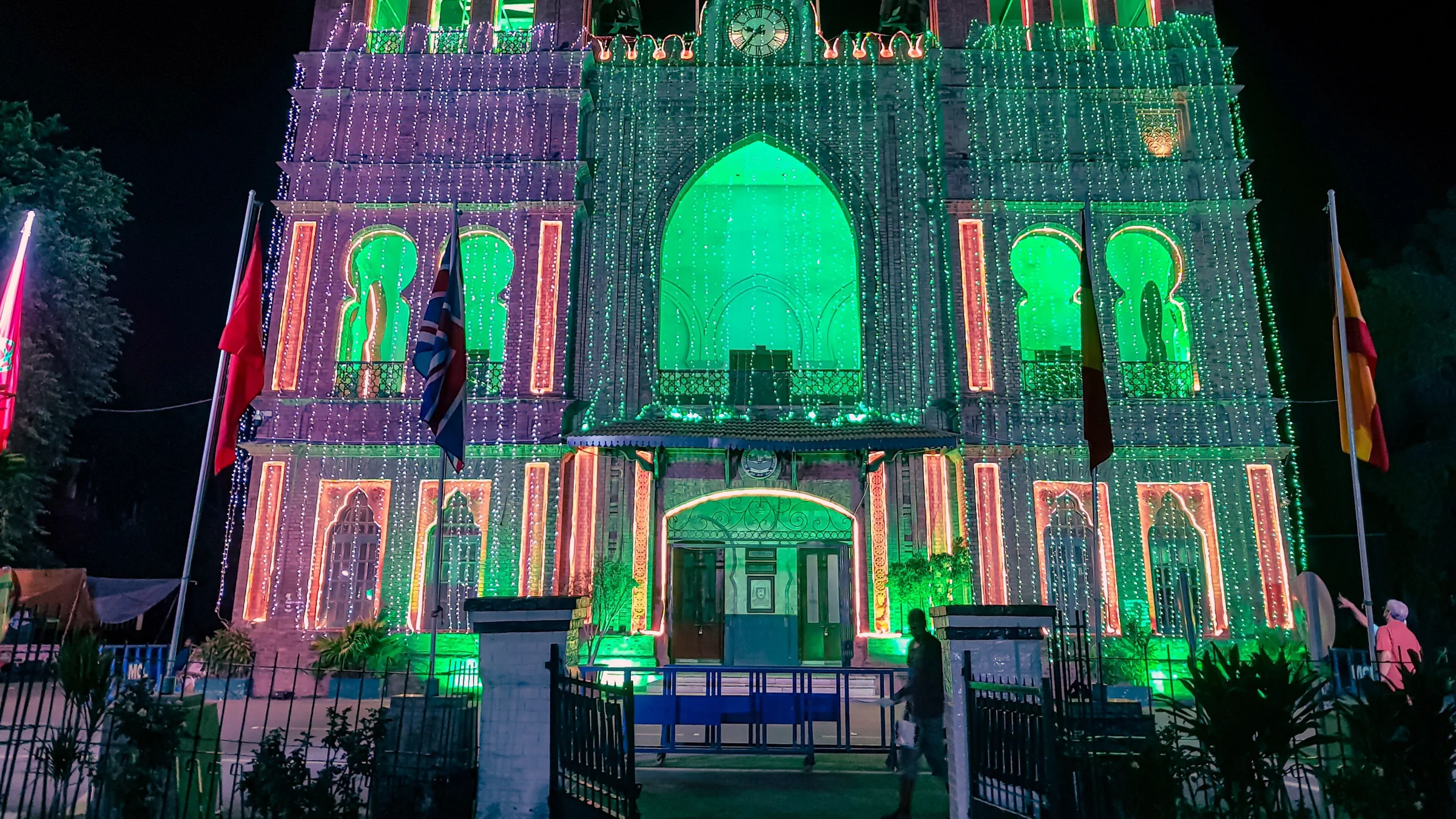 Lahore's Town Hall lit up in green and pink lights at night