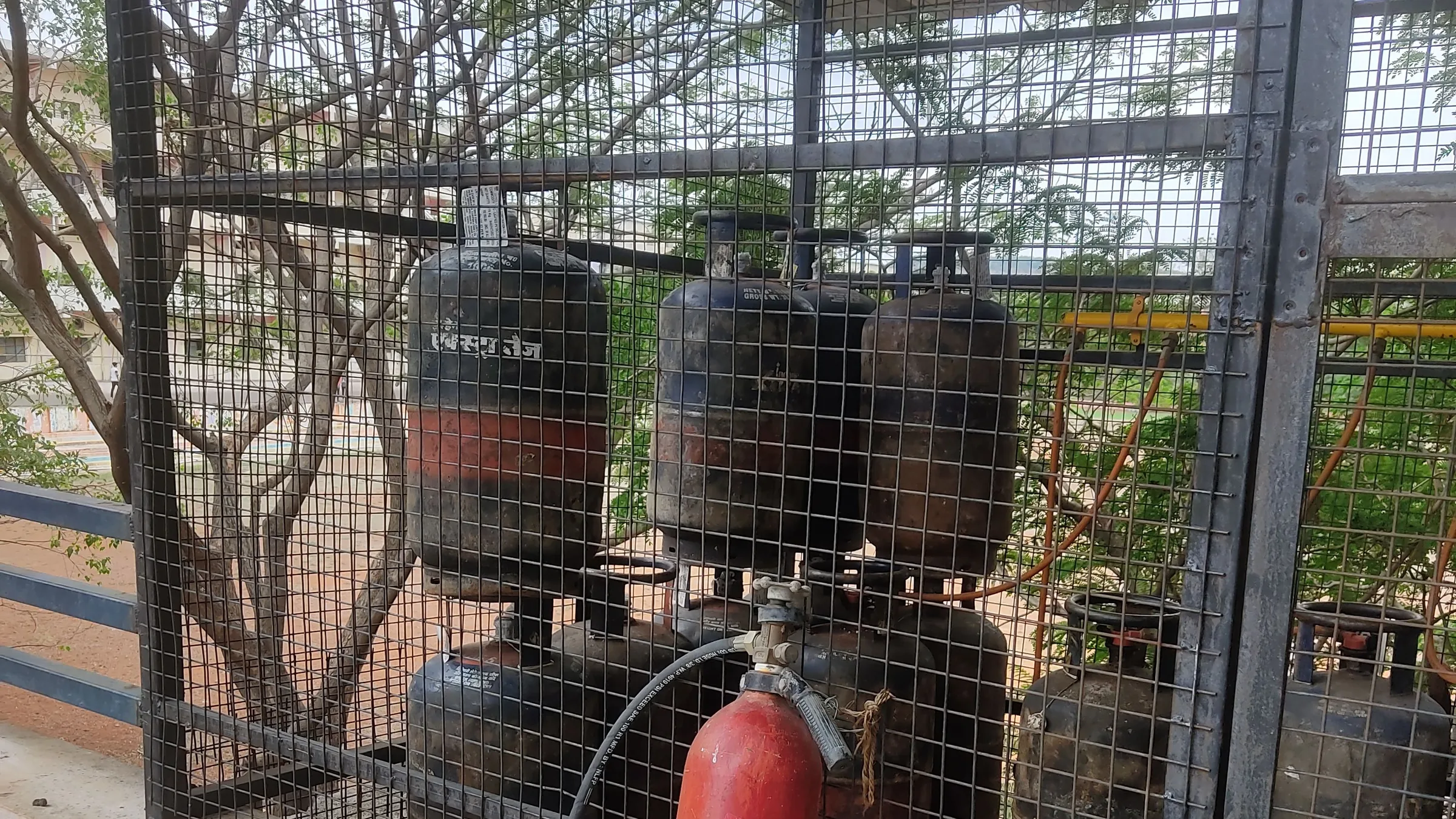 LPG cylinders stored in a metal cage next to a fire extinguisher