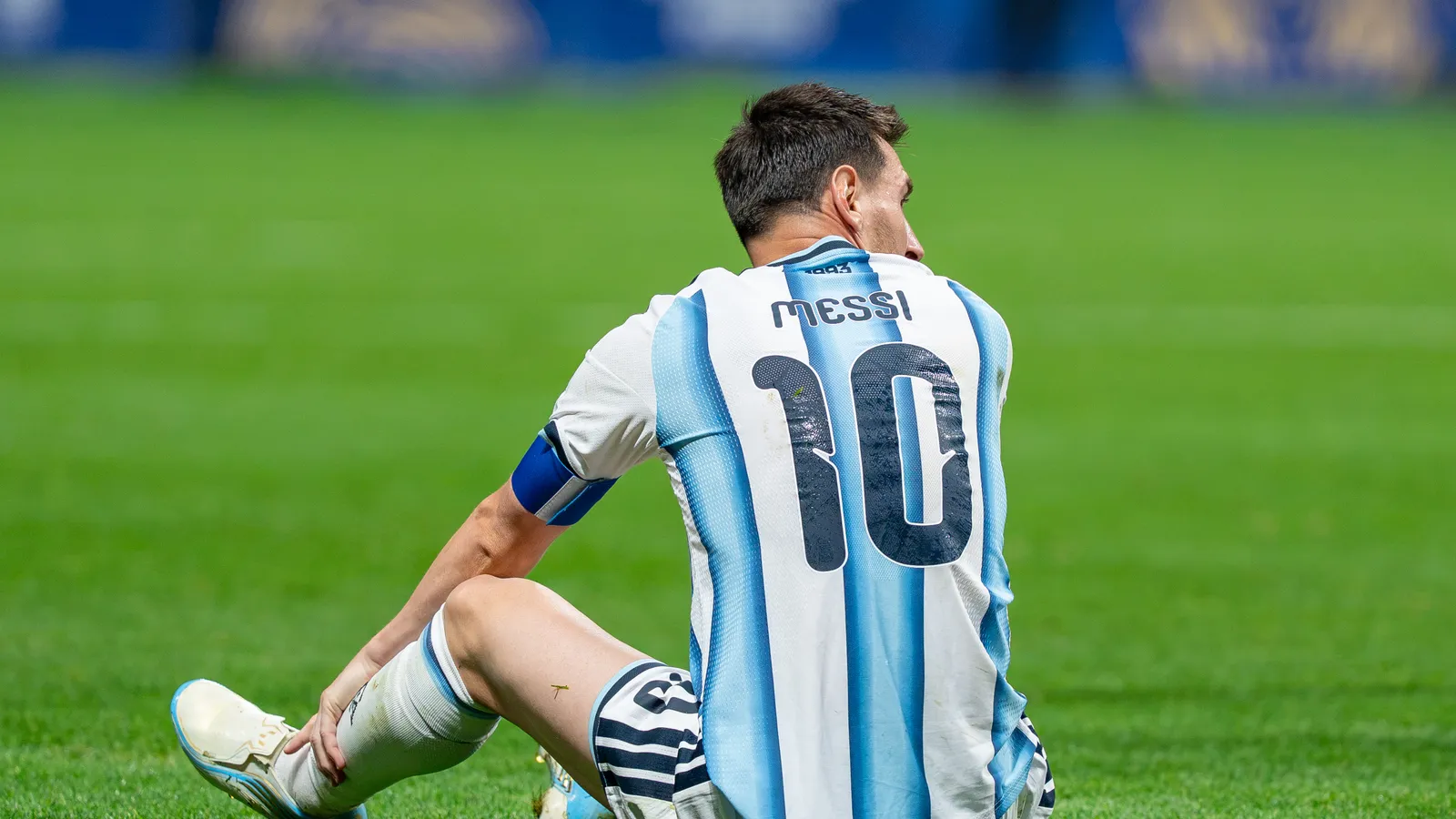 Lionel Messi sitting on the pitch in Argentina's number 10 shirt