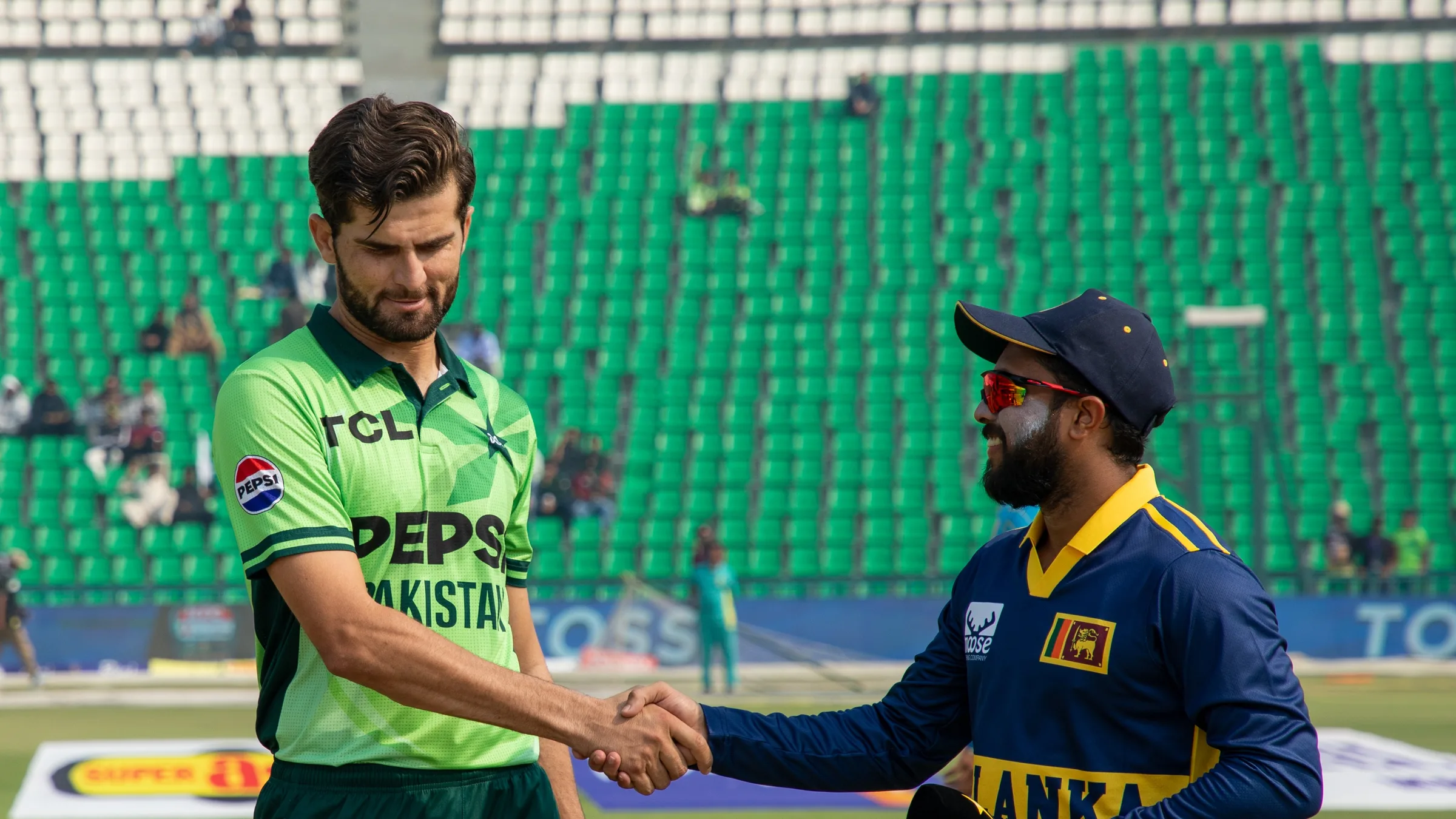 Pakistan captain Shaheen Shah Afridi in green shaking hands with Sri Lanka captain Kusal Mendis at the toss