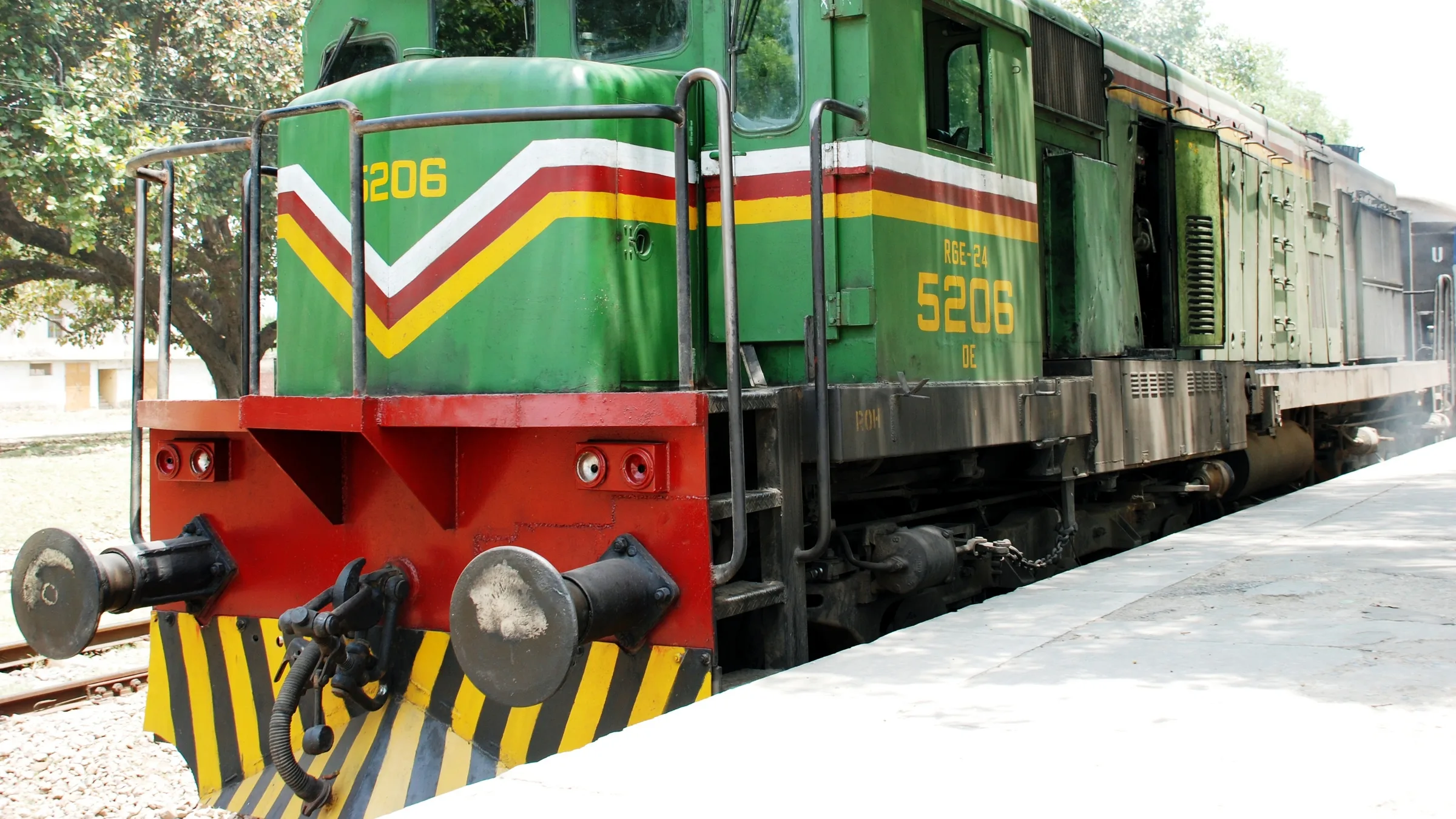 A green Pakistan Railways diesel locomotive at a platform