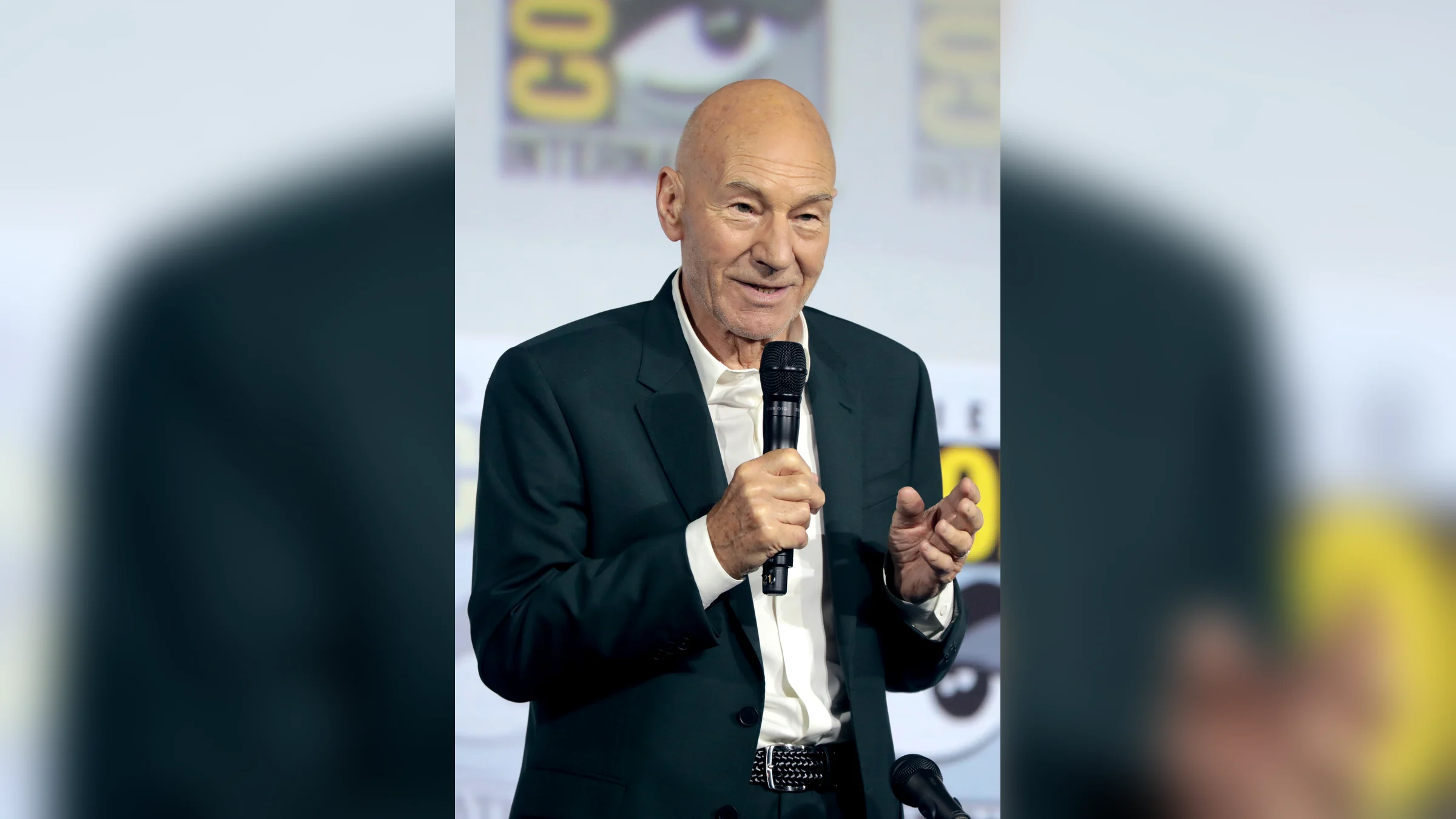 Patrick Stewart speaks into a microphone on stage at San Diego Comic-Con
