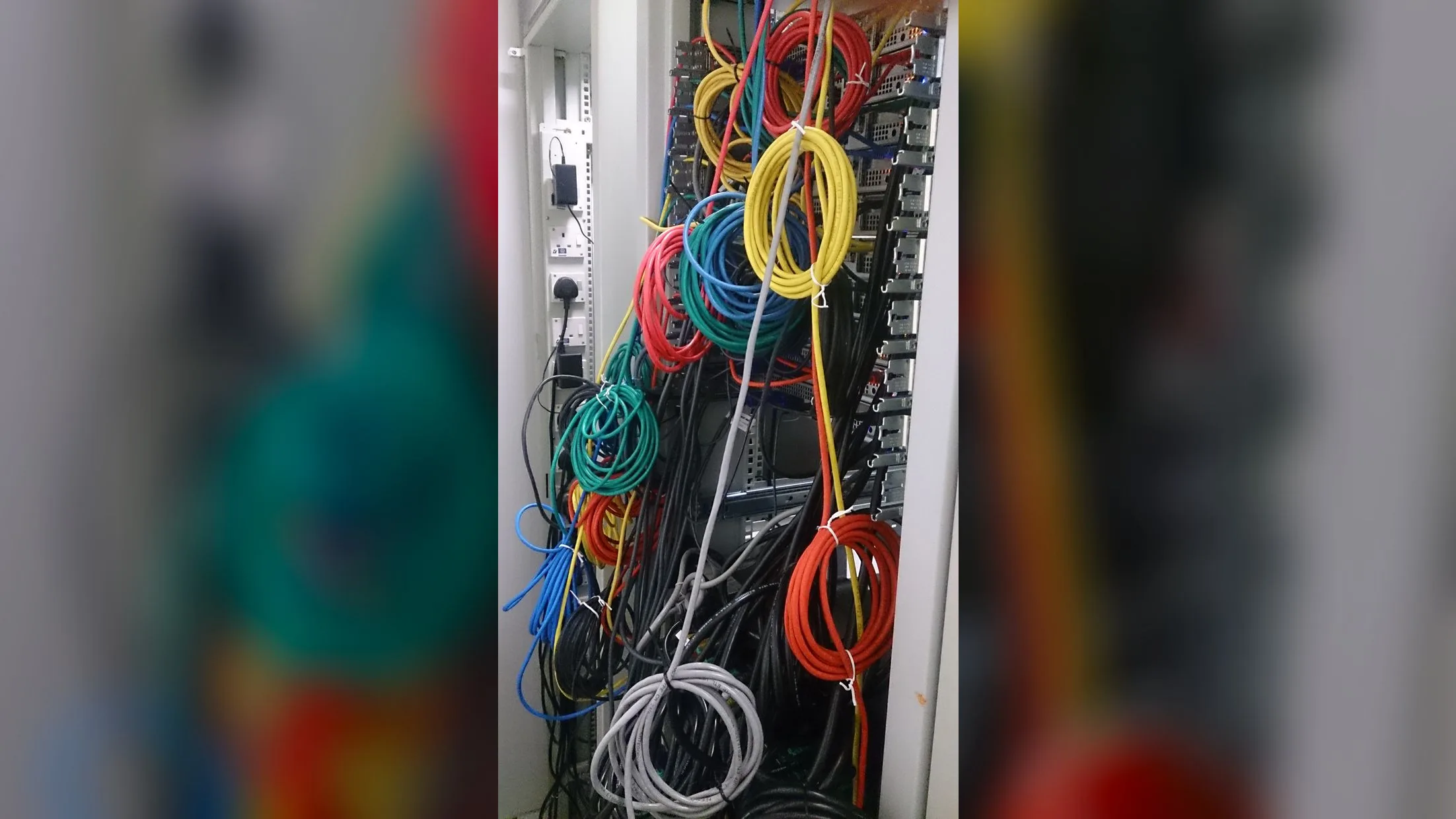 Bundles of network cables plugged into servers in a server room