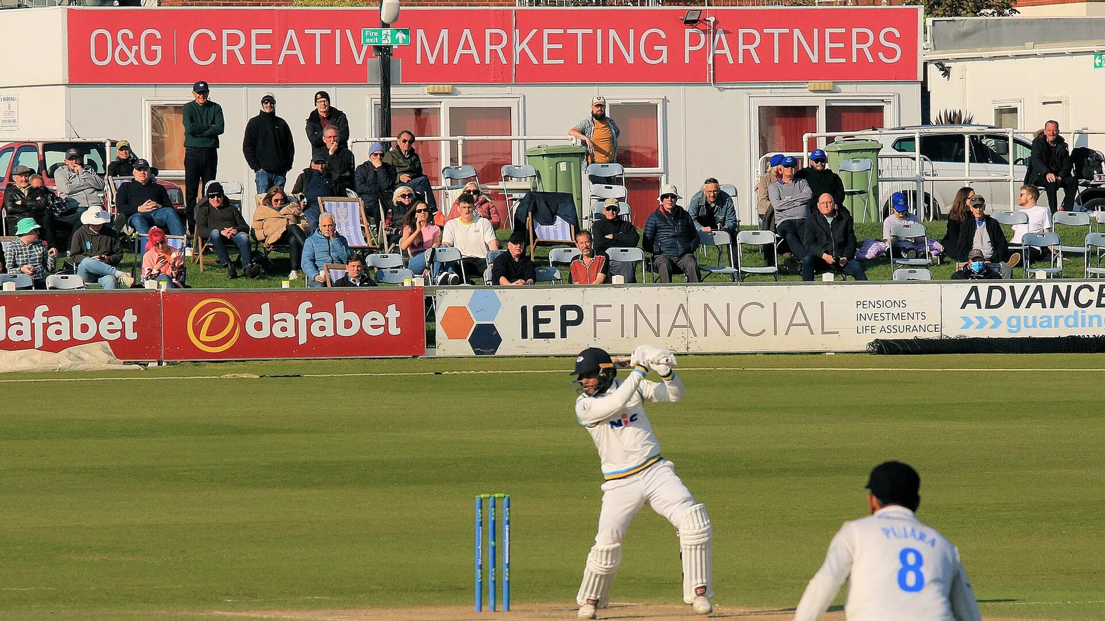 Shai Hope batting in a match as a fielder looks on