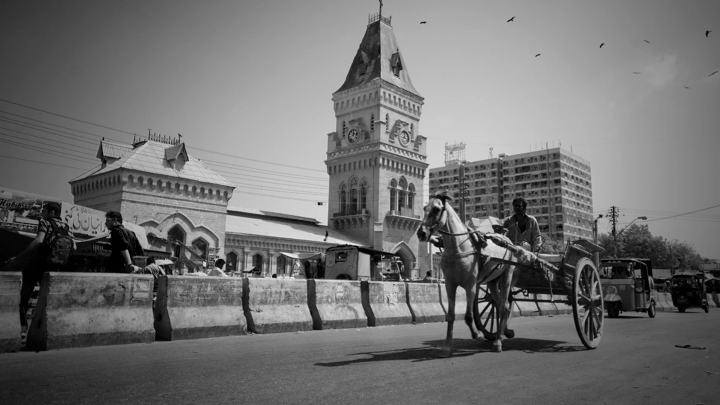 A horse cart passes Empress Market in Karachi in a black and white photograph