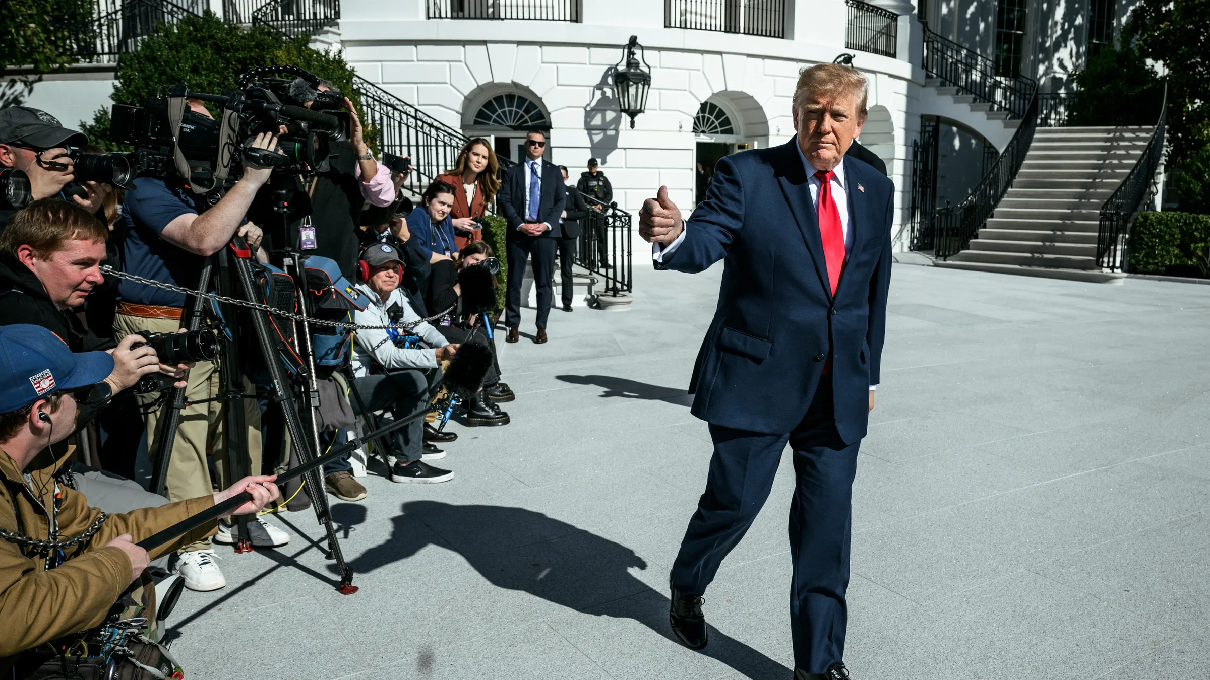 Donald Trump walking past reporters outside the White House