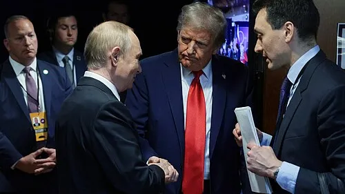 Vladimir Putin shakes hands with Donald Trump